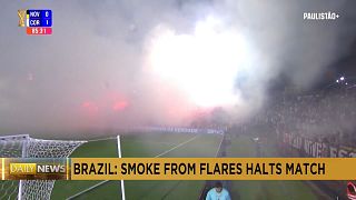 Brazilian state football match paused after fans smoke out the pitch